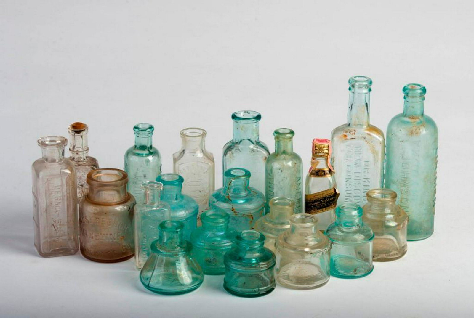 Group of Twenty Small Clear and Blue Glass Bottles: Height of tallest, Dr. Kings New DIscovery for Consumption, 7 inches. Also including Johnsons American Anodyne, Larkin Co. Derma-Balm, Whittemore Boston, and others.