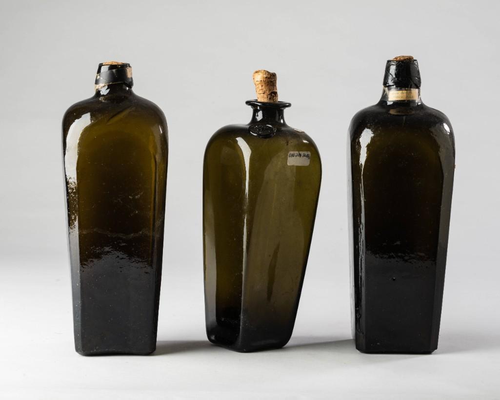 Three Nineteenth Century Green Glass Bottles.: Including two Dutch gin bottles, and a Vandenburgh gin bottle. Height of tallest 10 3/4 inches.