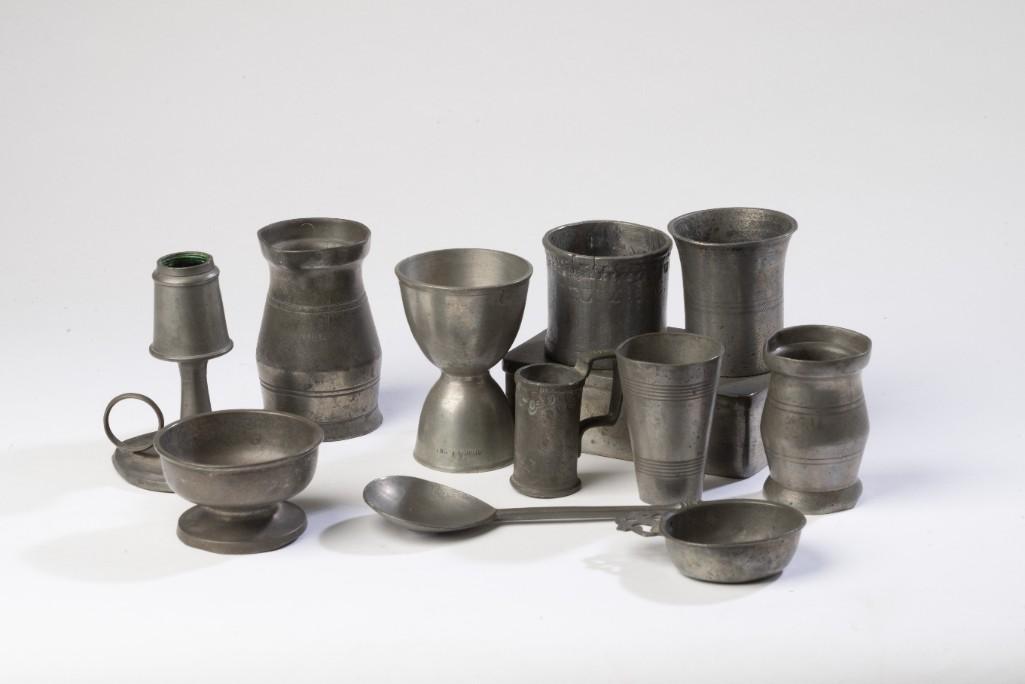 Group of Small Pewter Items.: Eleven items total, including three measures, two mugs, two beakers, footed bowl, spoon, and oil lamp (missing wick holder), height 3 7/8 inches.