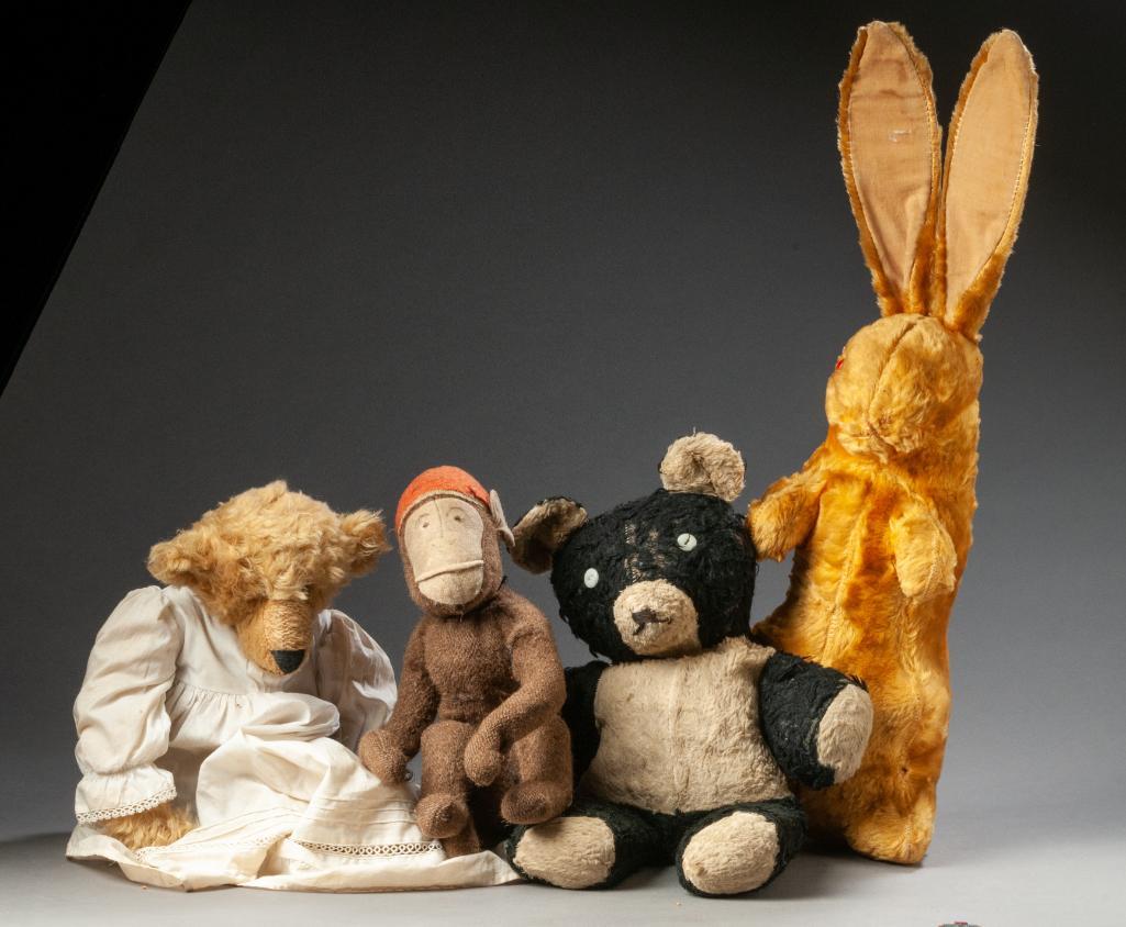 Four Stuffed Animals.: A monkey, likely part of a pull toy, height 11 inches. A black and white bear, height 17 inches. A Delton Products bear wearing a dress, and a valveteen rabbit, height 24 inches.