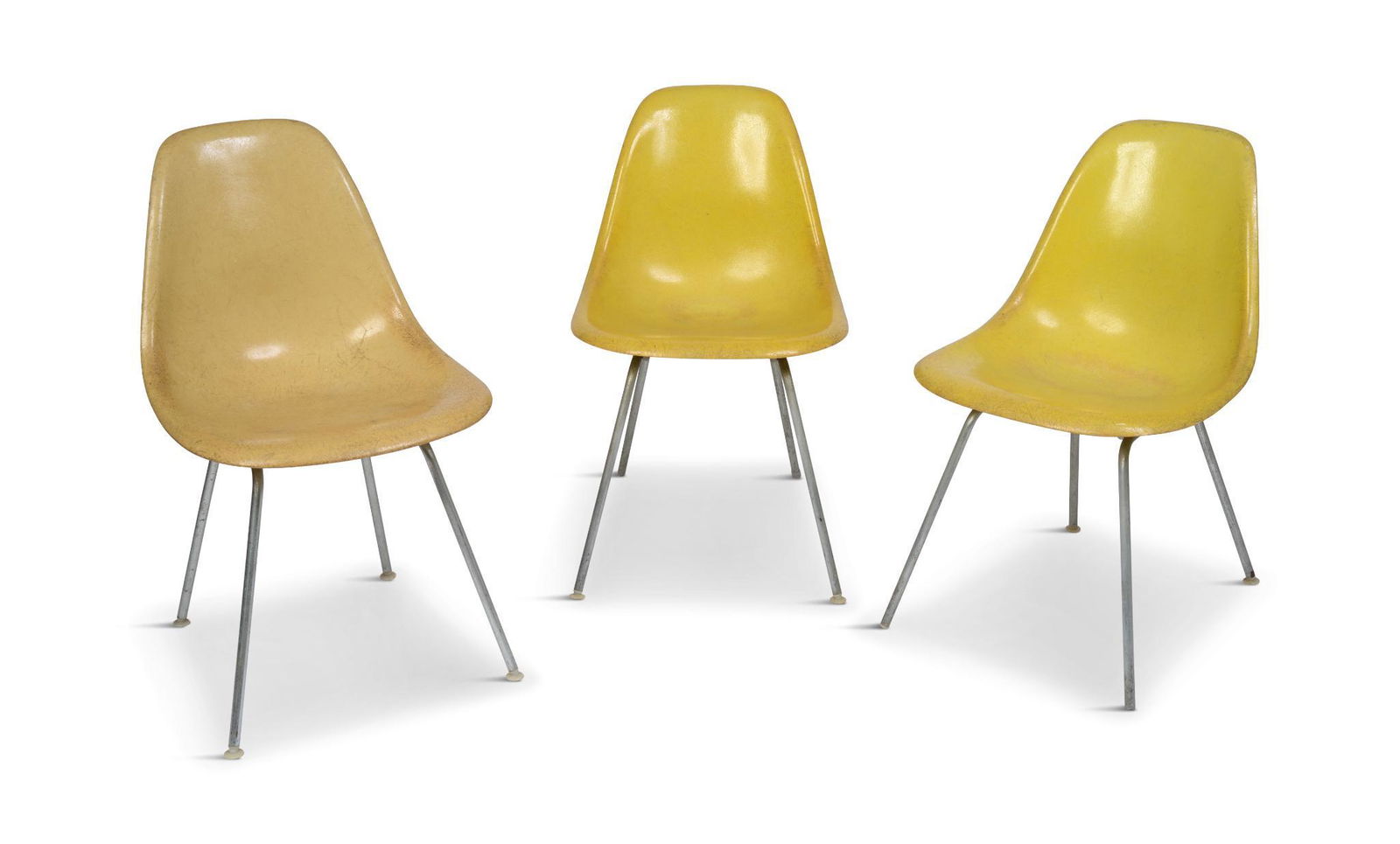 Three Herman Miller Chairs.: Fiberglass bucket chairs, wear to seats, one with two holes in seat.