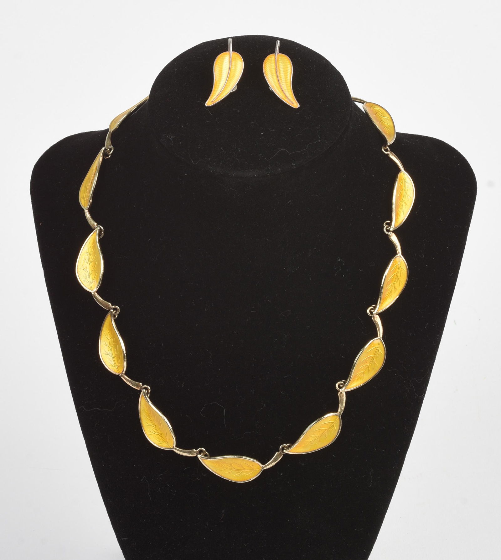 Pearl White Enamel Leaf and Sterling Necklace and: Necklace marked Meka, Sterling, Denmark. Length 8 inches. Earrings marked DA for David Anderson, 925 s, Sterling, Norway. Earrings are clip on style. Earrings length 1.25 inches.