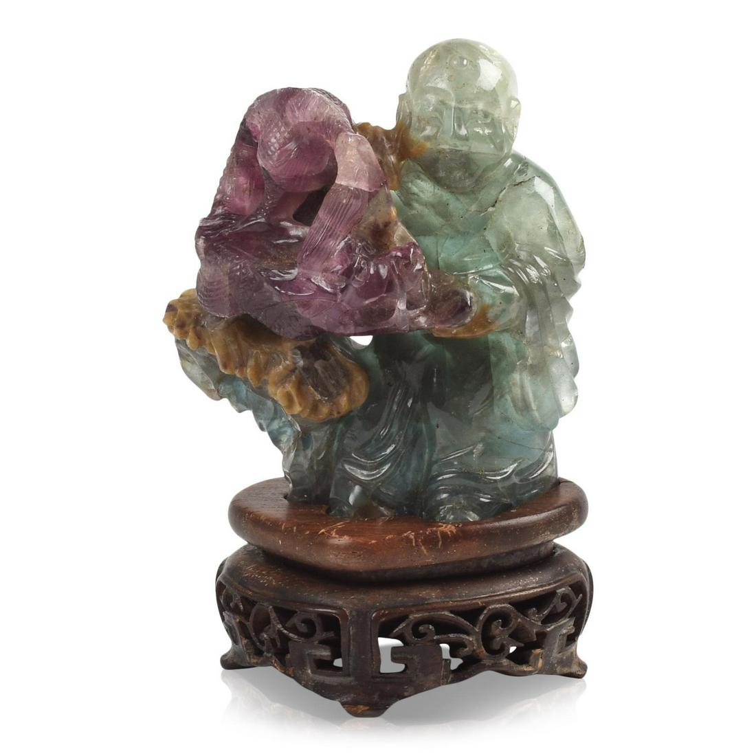 Chinese Two Color Flourite Carving Depicting a Luohan: Finely carved wood display stand, height 5.75 inches.