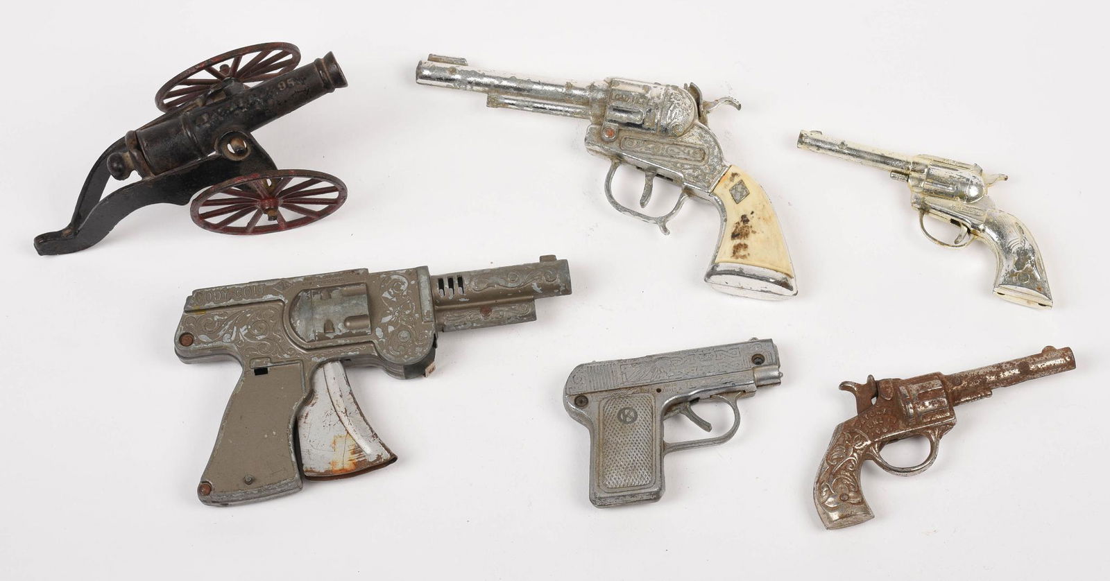 Group of Cap Guns.: Hawkeye, Copy Colt, and three revolvers. Together with a cast iron Parade Canon.