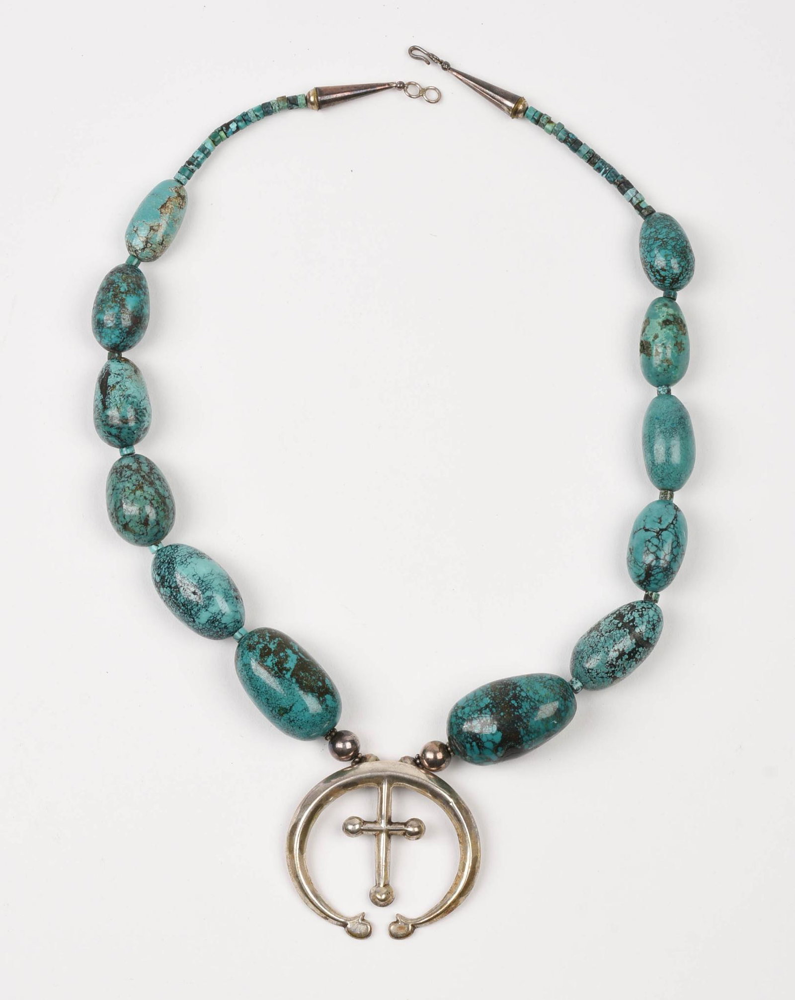 Navajo Turquoise And Sterling Necklace.: With graduated turquoise beads, 1.125 to 1.625 inches, and a removable sterling pendant, 2.125 x 2.5 inches. Total weight 188 grams.