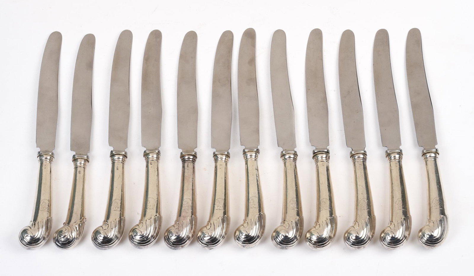 Twelve Sterling Pistol Grip Knives.: Engraved with the crest of the Trotter family, marks rubbed. Length 9.5 inches, total weighable 878 grams.