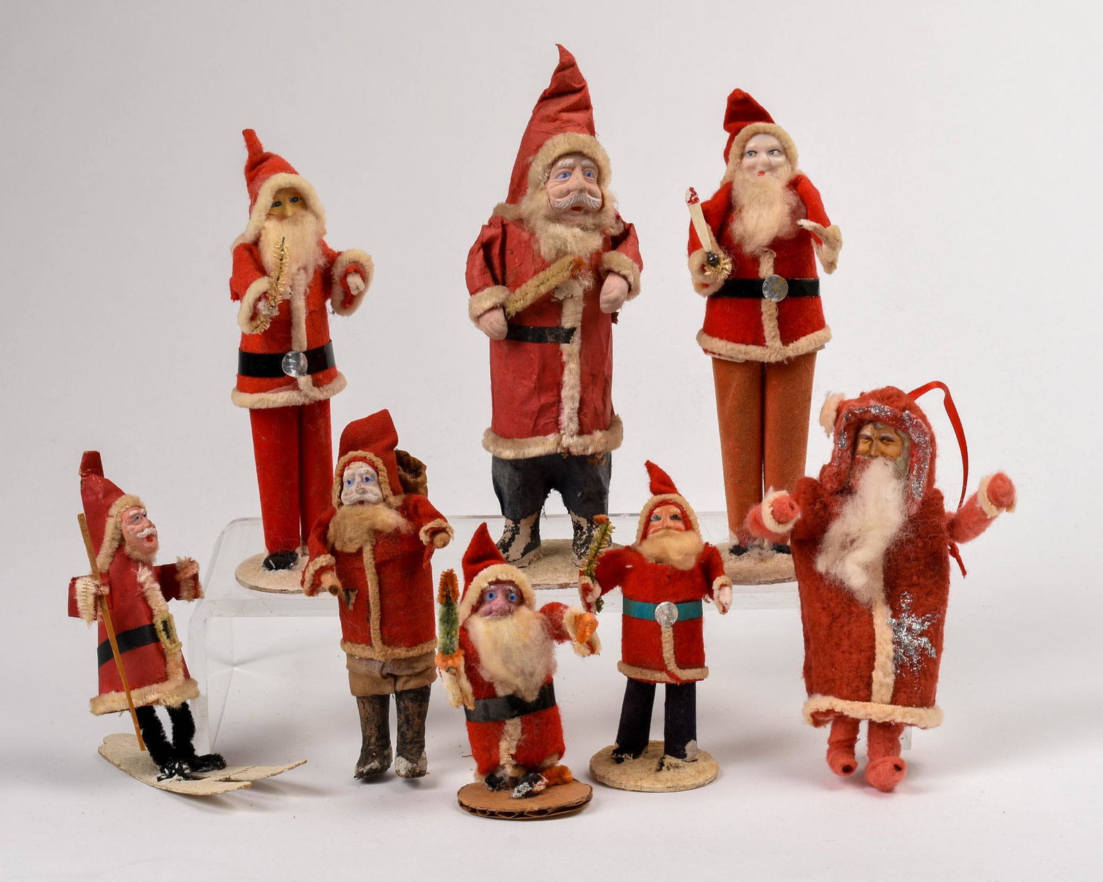 Eight Vintage Santa Figurines: Heights 3.5 to 7.25 inches.