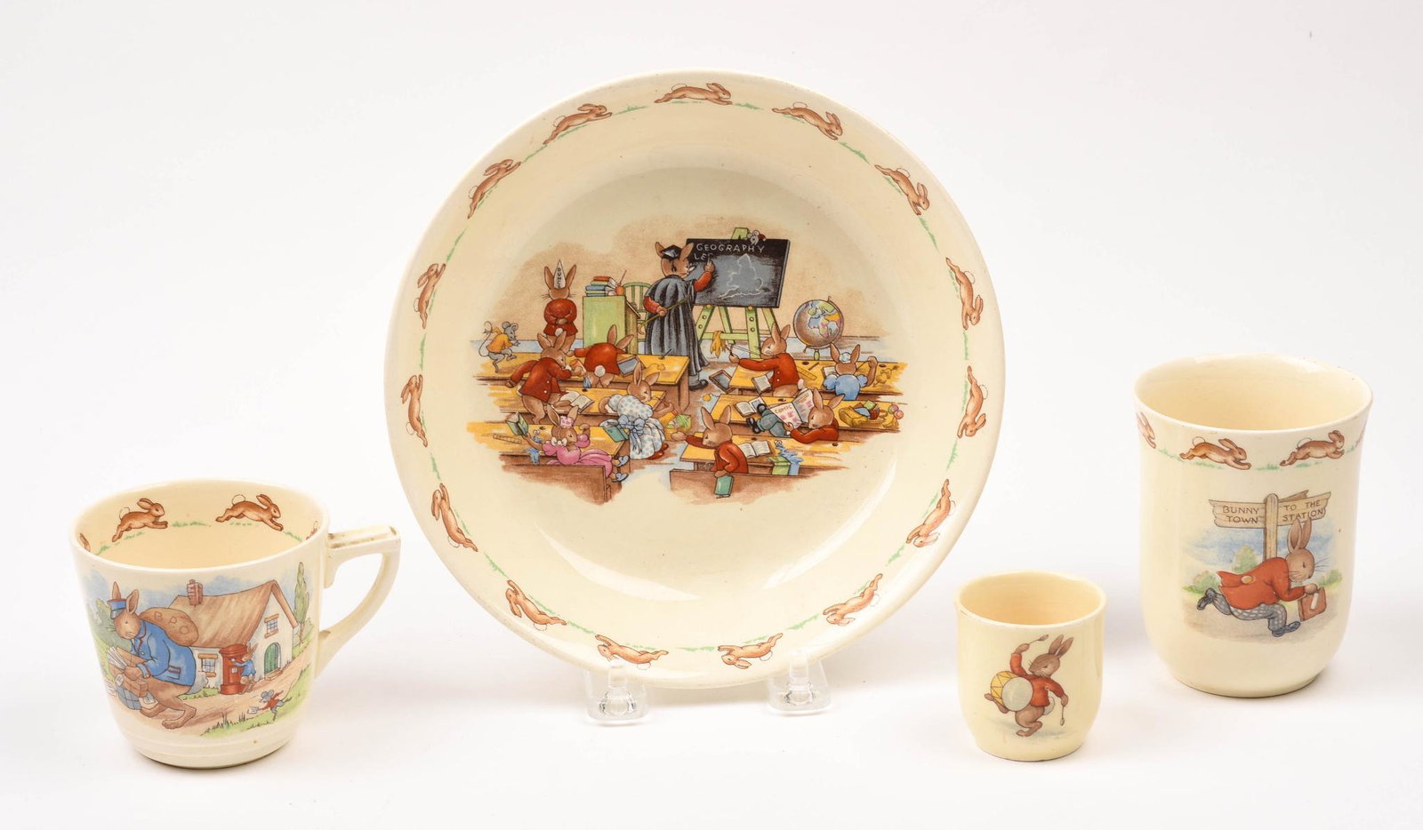 Four Royal Doulton Bunnykins Pieces.: A bowl, diameter 7.5 inches, and three mugs, heights 3.75, 2.75 and 2 inches.