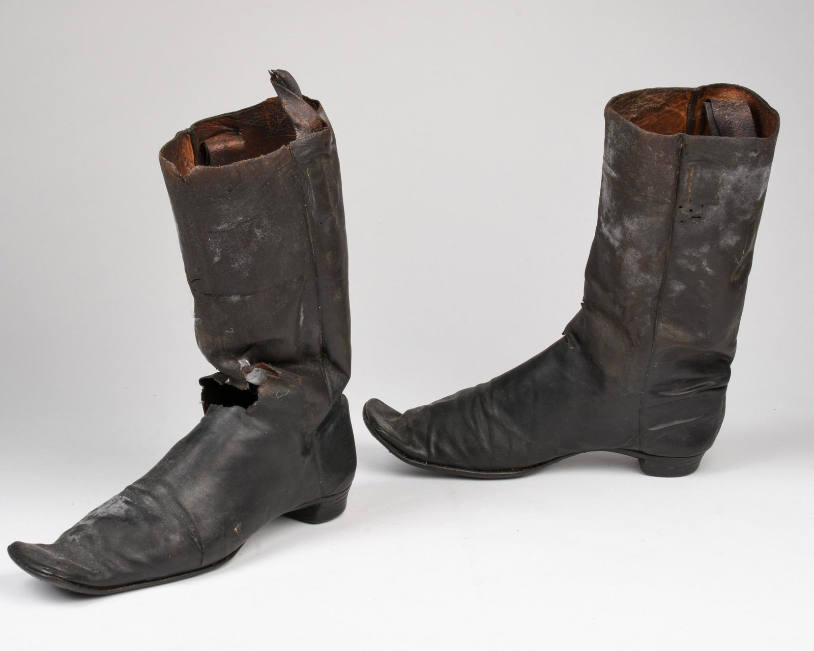 A pair of men’s half boots, circa 1840: Stylish pair of black boots with pronounced square toes and narrow heels, side-seam construction. A type commonly used by dismounted military officers, as well as popular among stylish men. A 2-inch s
