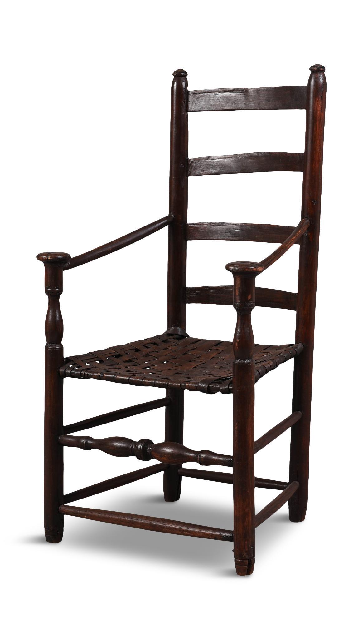 American Ladder Back Armchair.: With mushroom cap arms, circa 1750. Seat height 16 inches, height to top rail 39.5 inches. Legs pieced out, backs of finials cut for what appears to have been a later crestrail, which has been removed