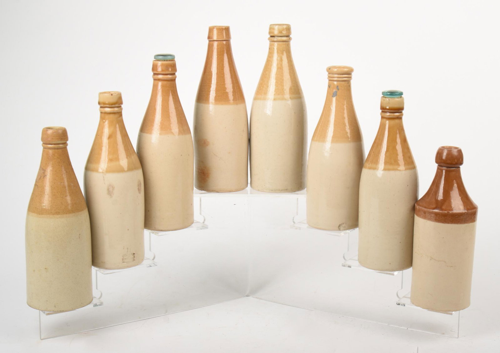 Eight Stoneware Bottles.: Heights approximately 8 inches.