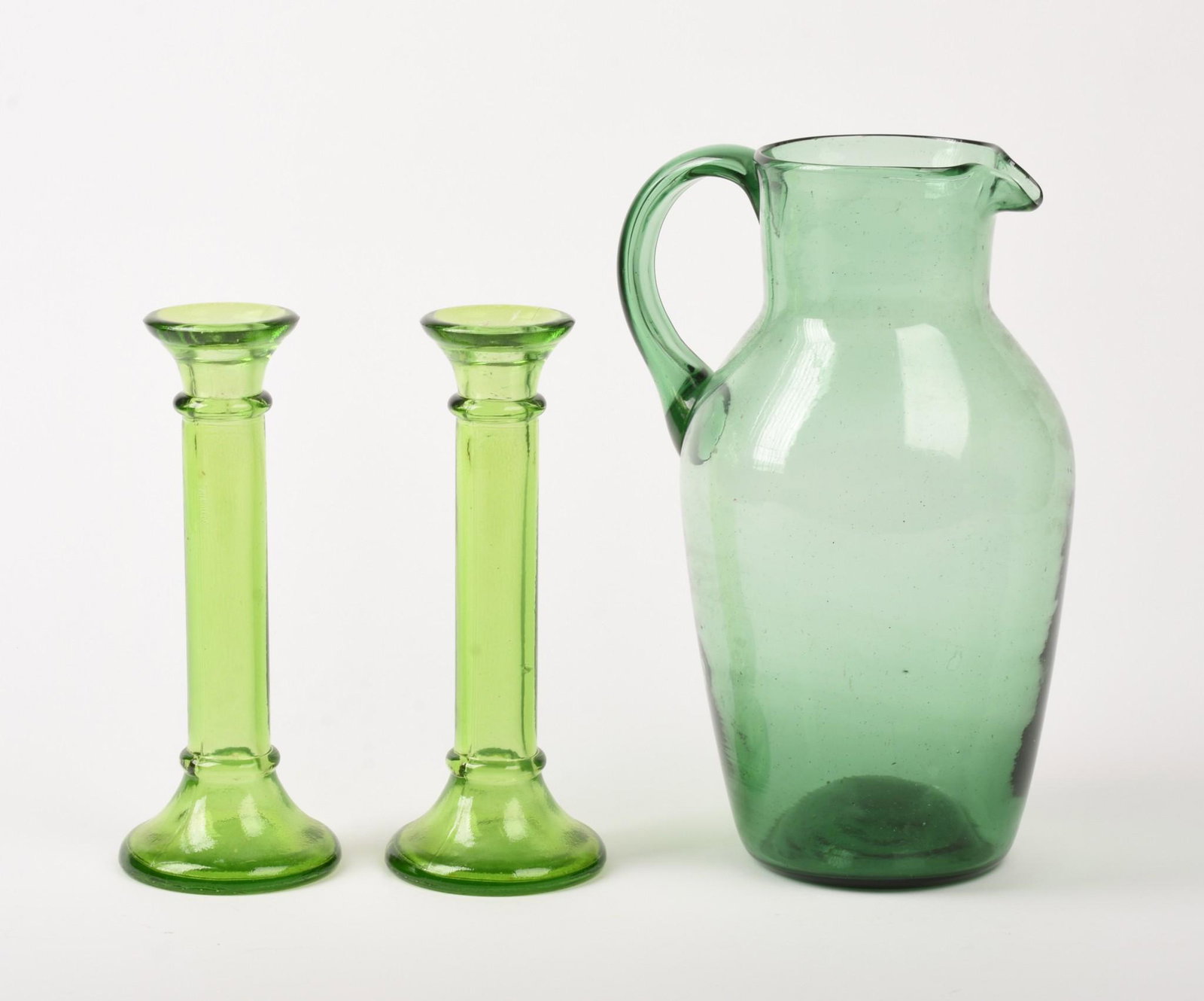 Green Blown Glass Pitcher.: 20th century, height 10.25 inches. Together with a pair of green glass candlesticks.