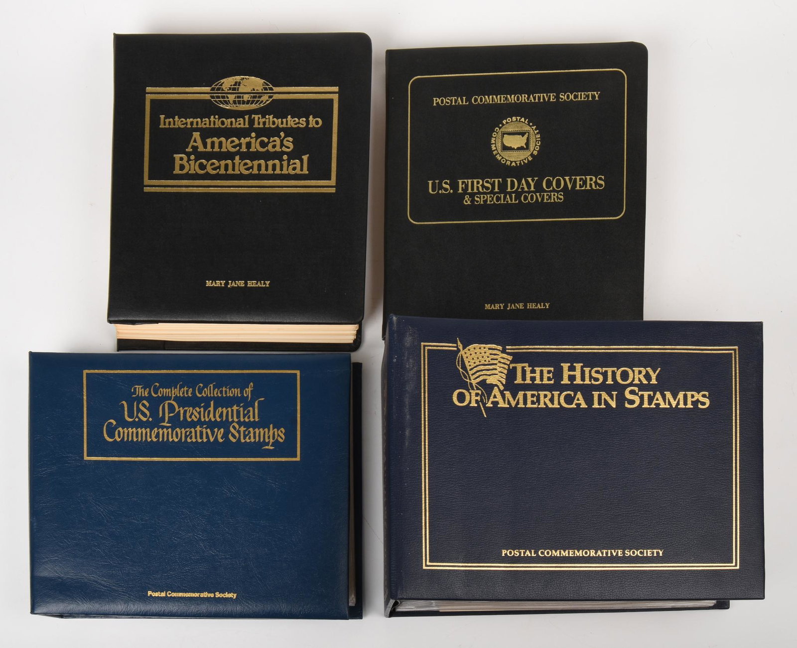 Four Binders of Historic American Stamps.: Postal Commemorative Society, excellent condition. Including International Tributes to America's Bicentennial, The Complete Collection of U.S. Presidential Commemorative Stamps, The History of Ame