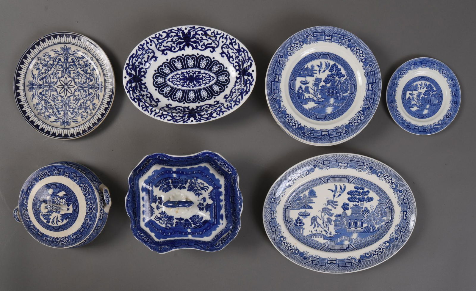 Group of Blue Willow Wares.: North Staffordshire Pottery platter, 14 x 11 inches, two covered tureens, 6 Ridgeway dinner plates, saucer. Together with two other blue and white porcelain pieces.