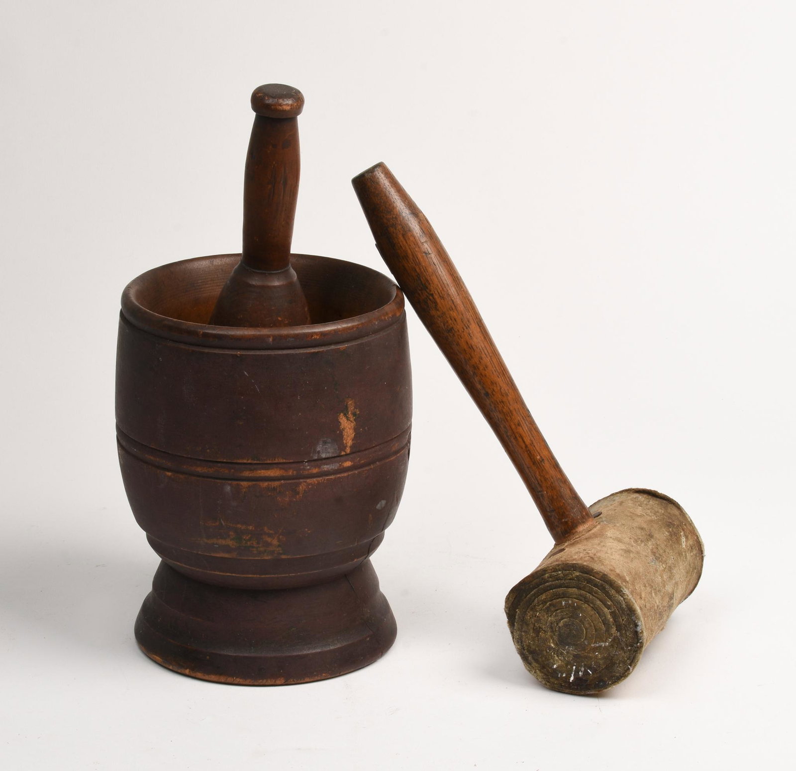 Mortar and Pestle in Dark Brown Stain.: Height of pestle 7.75 inches, crack to one side. Together with a mallet with leather head, length 12 inches.