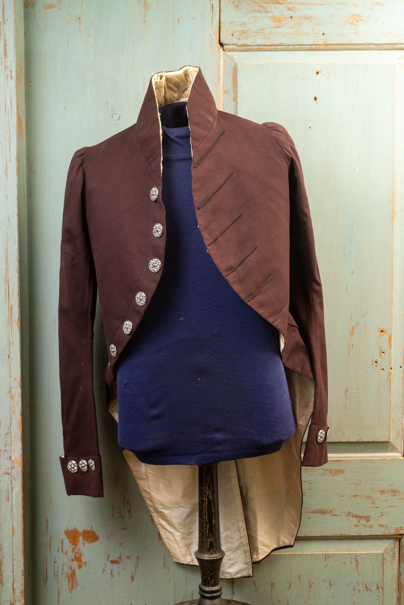 EARLY 19TH C. MAROON WOOL ENGLISH LIVERY COAT.: with cut steel buttons, 3" high standing collar, padded with white silk lining