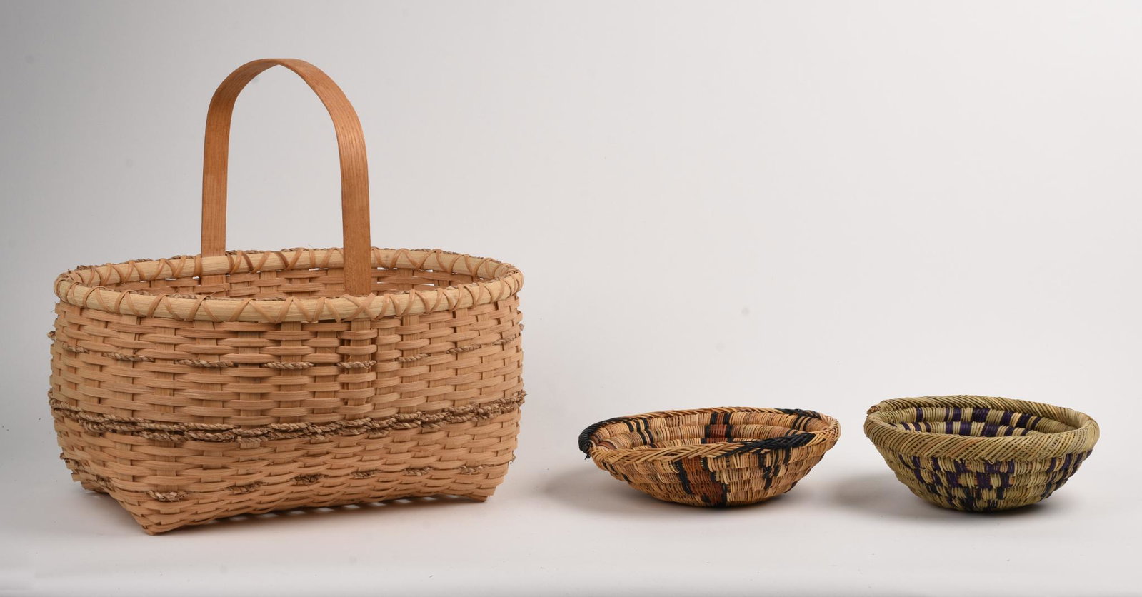 Many Nino Basket With Handle.: Mohawk. 1996. Height over handle 15 inches. Together with two sweet grass baskets, diameters 8 and 9 inches.