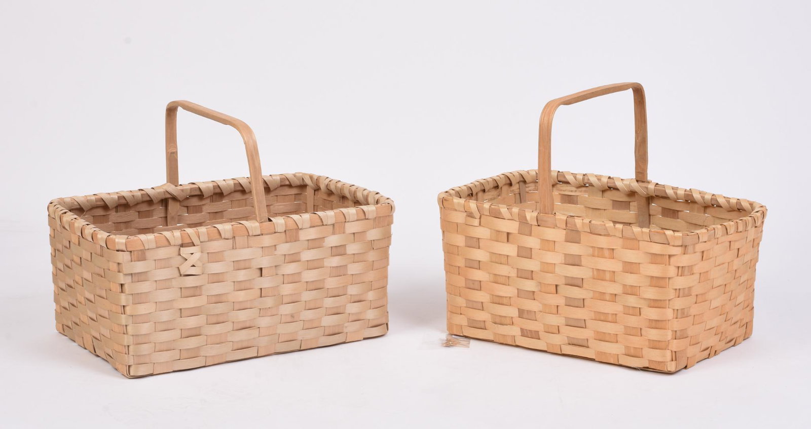 Two Peter Neptune Wabanaki Woven Baskets.: 2000 and 2019. Open with handle, lengths 17 and 19 inches. With set of woven earrings.