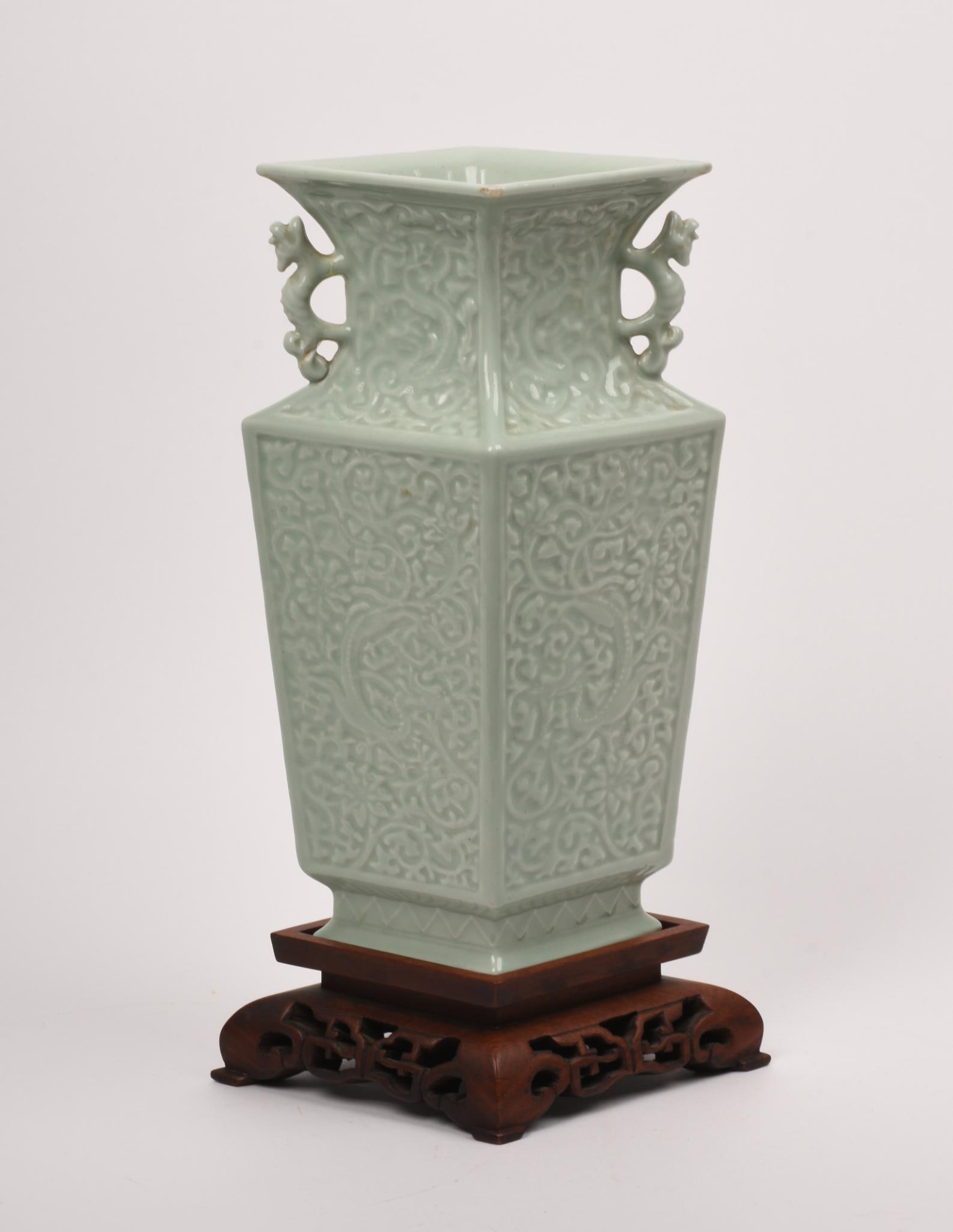 LARGE CHINESE CELADON PORCELAIN VASE: 4 panels decorated with dragons, dragon handles, wooden stand, as is, drilled, height 14 inches.