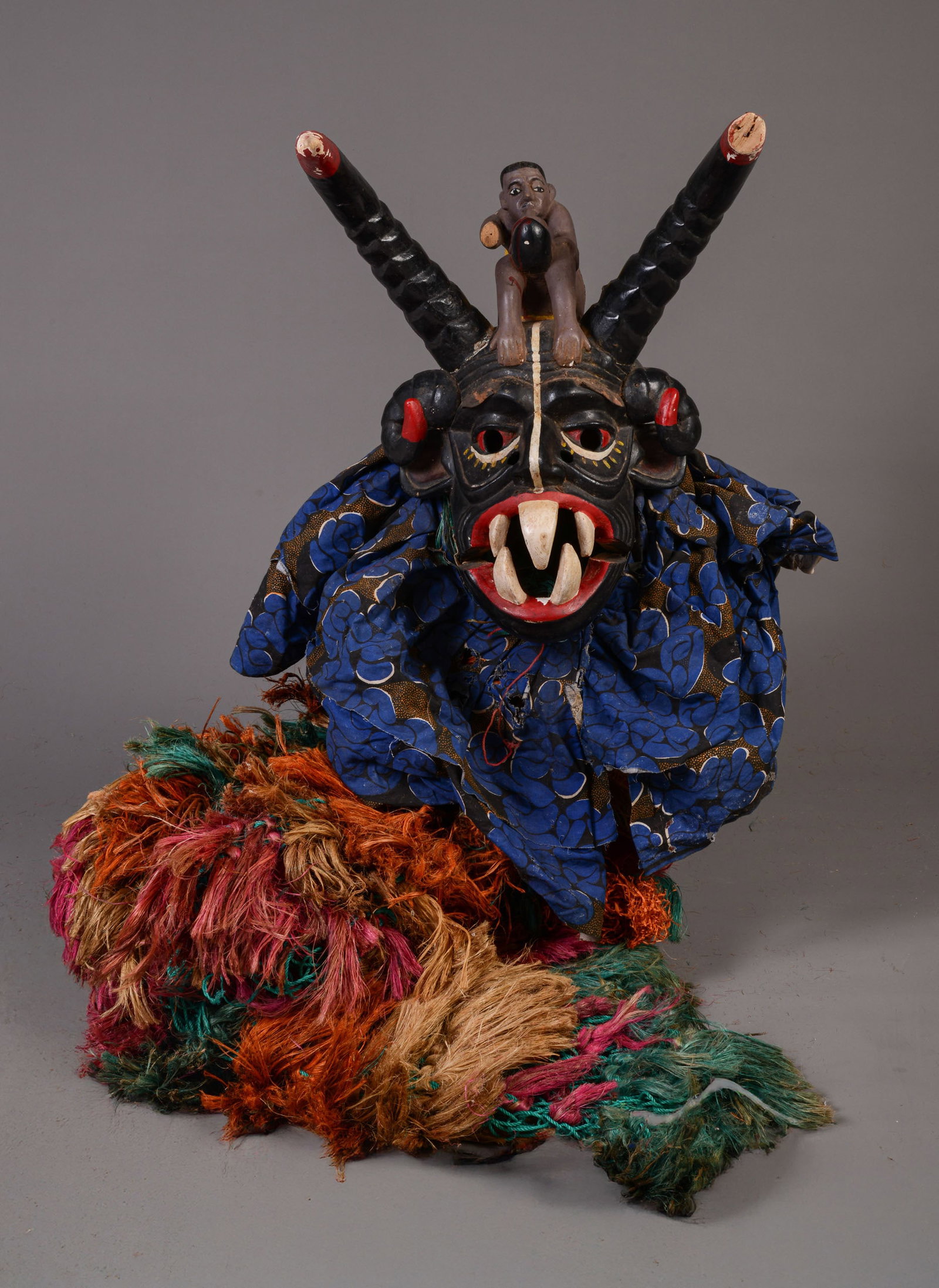 OKWO-NMA AGABA HEADDRESS: Height of mask 24 inches, approximately 73 with textile attachment. Width Old repairs to horns and wrestlers. Wrestler missing an arm, ome horn missing its tip. Jaw articulates. Cracks and losses thro