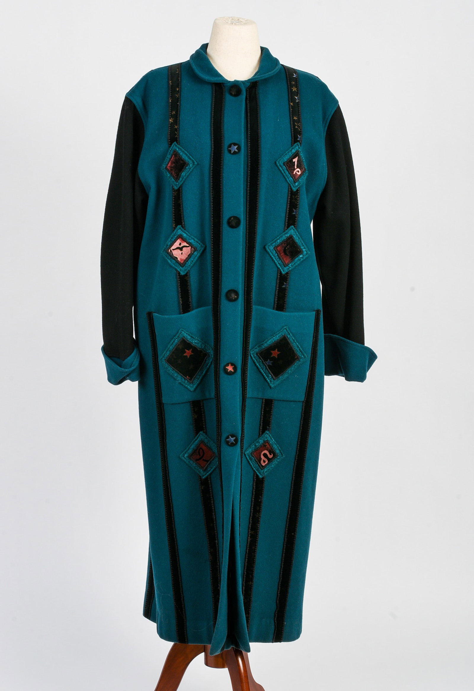 Coloratura Long Aqua and Black Coat: With snap closures, front pockets and diamond shape and velvet strip applique, lined, length 51 inches, appears to be a size 12, good condition.