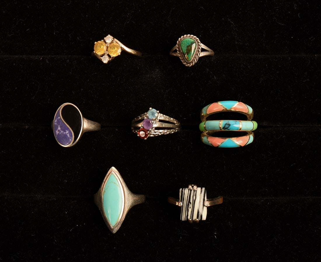Seven Rings: Four marked either sterling or 925. Size of ring with turquoise like stone 7. Smallest ring, with dark green stone, size 5.25.