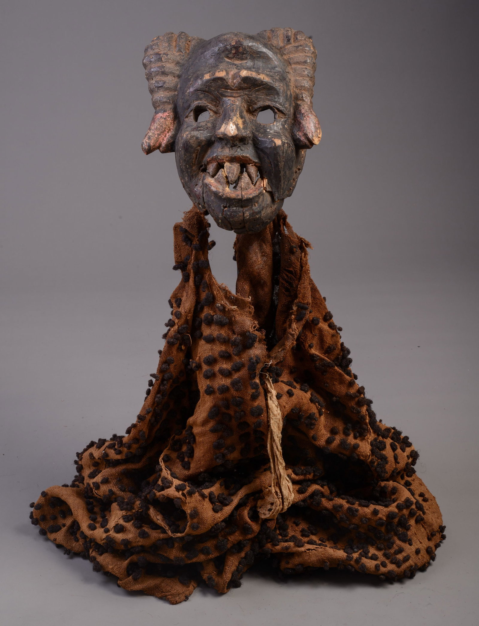 IGBO GRANDMOTHER'S MASK: Height 12 inches, width 10 inches. Cloth is detachable. Losses to the nose and eyebrows. Jaw is broken and loose with an old repair.
