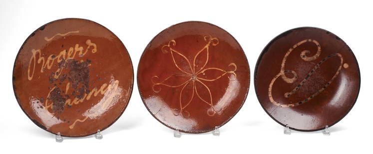 Three Early American Slip Decorated Redware Plates.: Diameters 13, 12 and 11.25 inches. Rim chips to all, hairline cracks to two smaller plates. SHIPPING: We offer very competitively priced in house shipping for all items in this sale. Please contact us