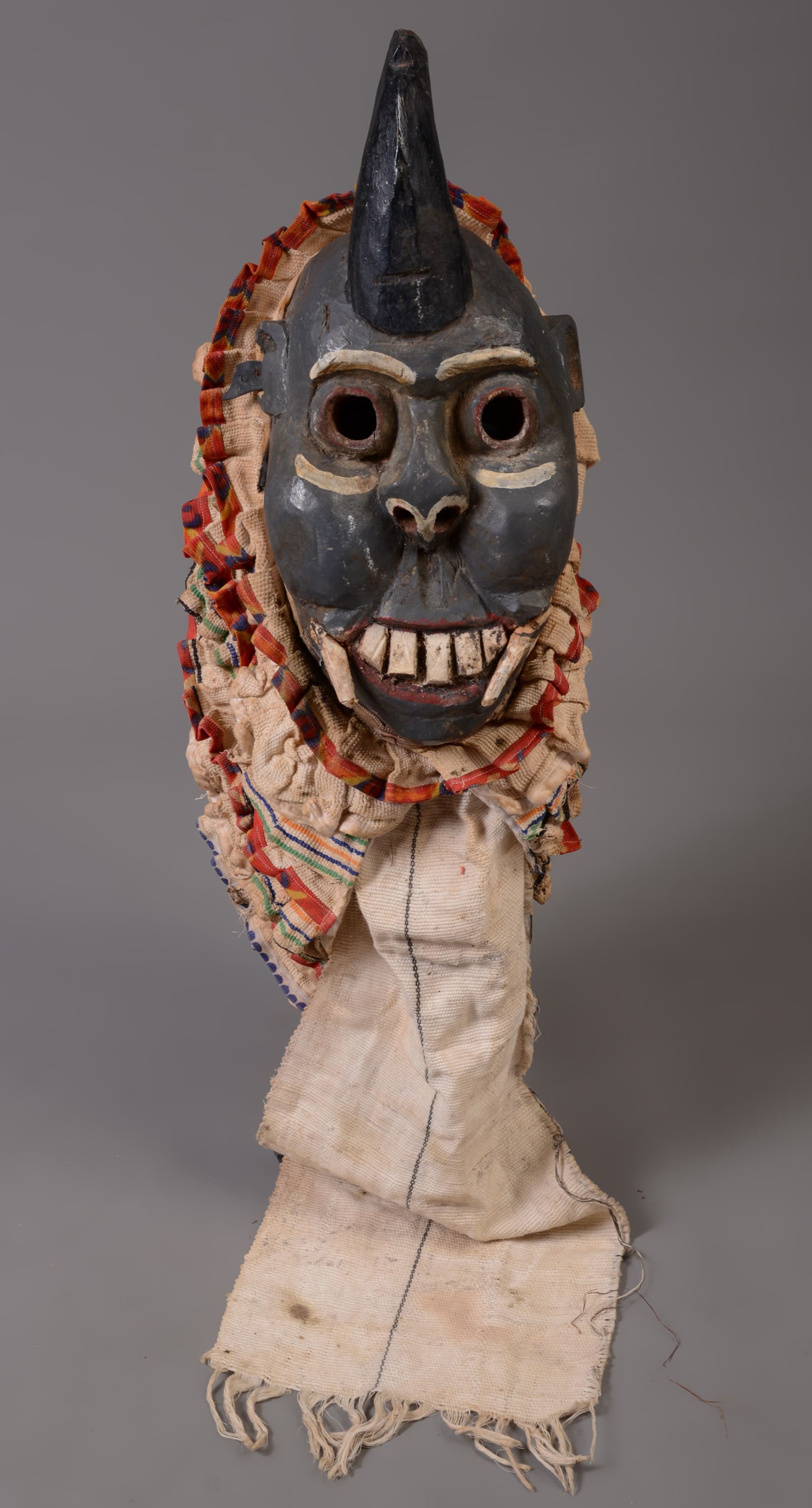 Spirit of Wisdom Mask With Costume from Igbo, Nigeria.: The showing of teeth represents the following of law or rule. Height 17 inches, width 8 inches without textiles. Cracks consistent with age. Old repairs to teeth. SHIPPING: We offer very competitively