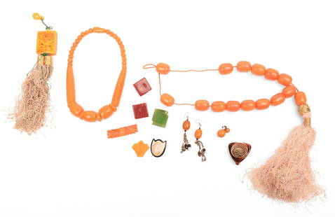 Group of Bakelite Jewelry: Two necklaces, lengths 30 and 40 inches, two pairs of earrings, five pins, and a large pendant. IN HOUSE SHIPPING: We offer very competitively priced in house shipping for all items in this sale.
