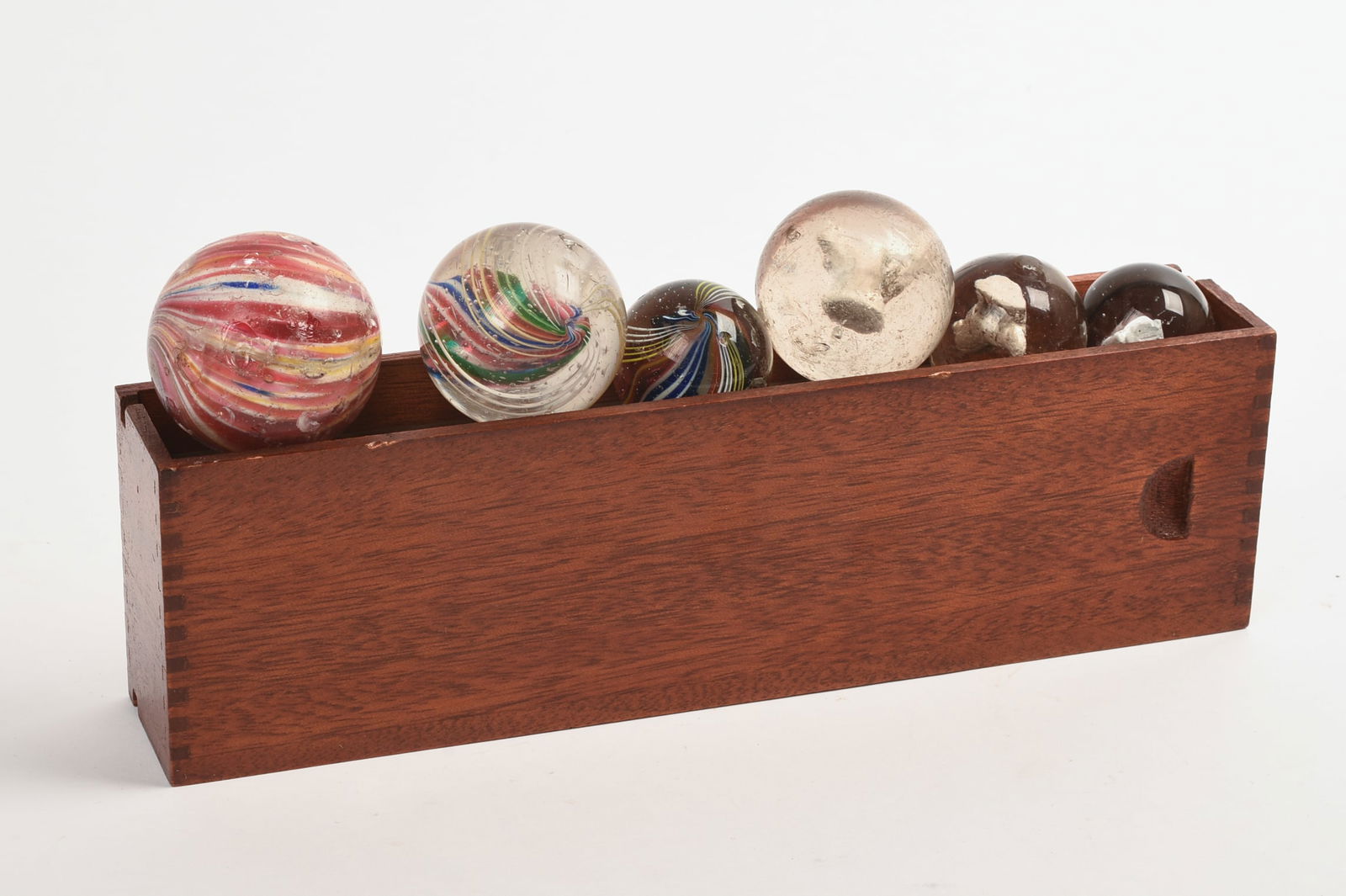 SIX ANTIQUE MARBLES: Including three Sulphides, diameters 1, 1.25 and 1.5 inches, and three others. Some chips. In a dovetailed box.