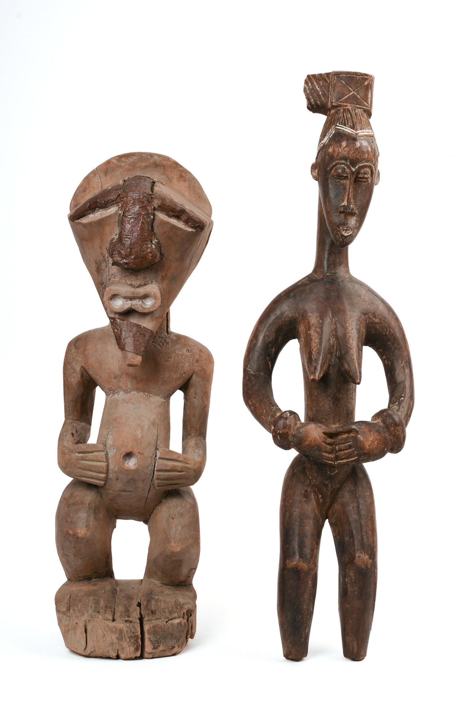 TWO AFRICAN CARVED WOODEN FIGURES.: Heights 19 and 22.5 inches. Female figure with breaks at hair knot and feet.