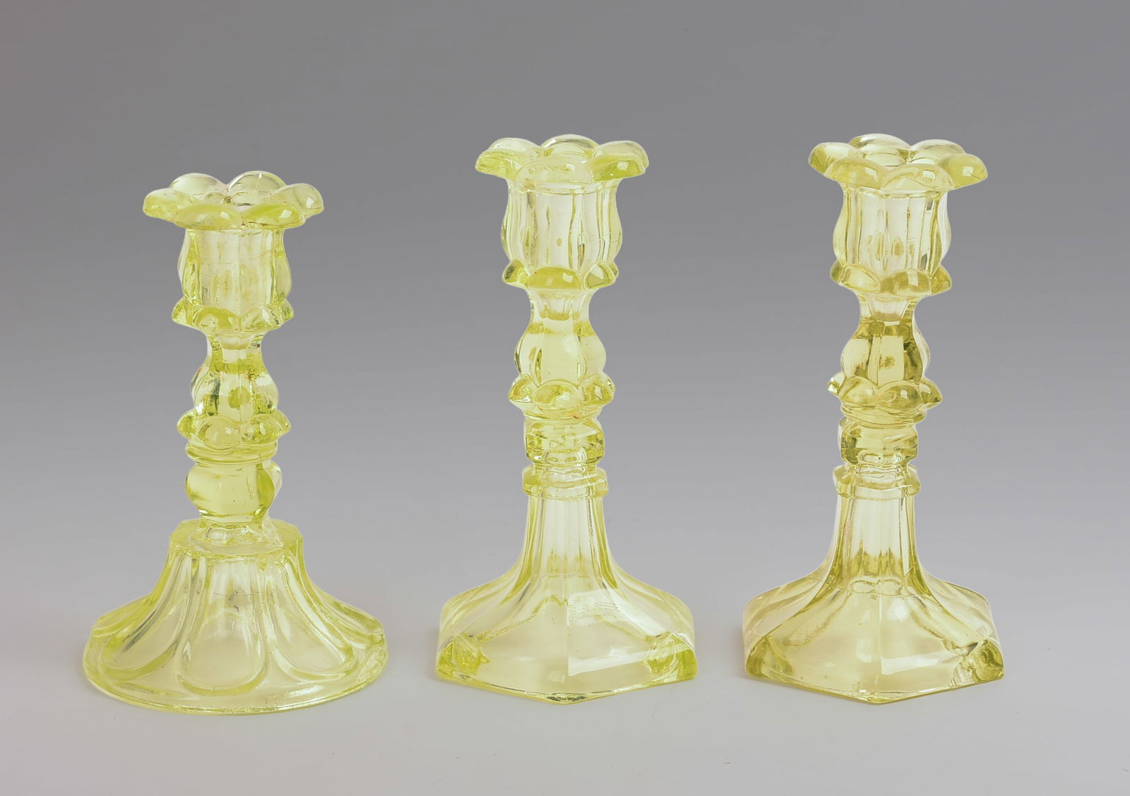 Three Yellow Glass Candlesticks.: Height 7.5 inches. Some small chips.