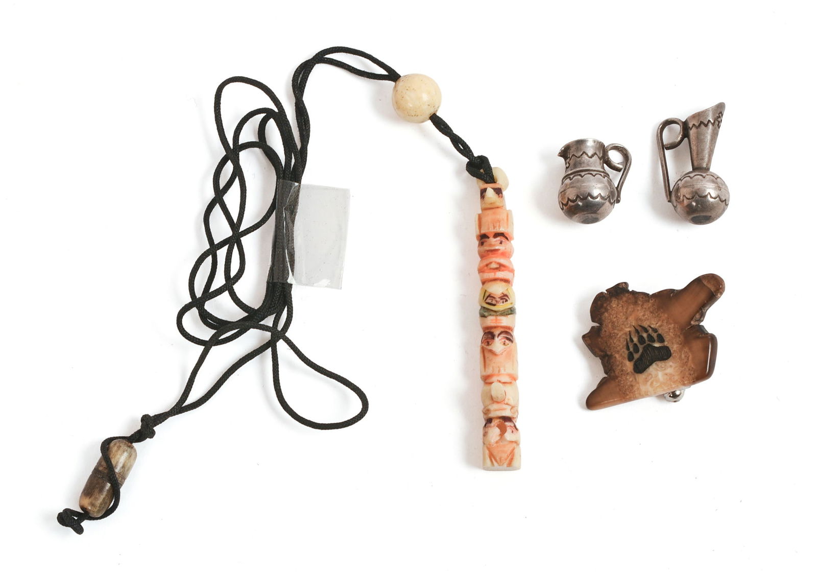 Three Native American Jewelry Pieces.: Carved bone totem pendant, length 2 inches, petrified wood pin, and a pair of jug form sterling charms.