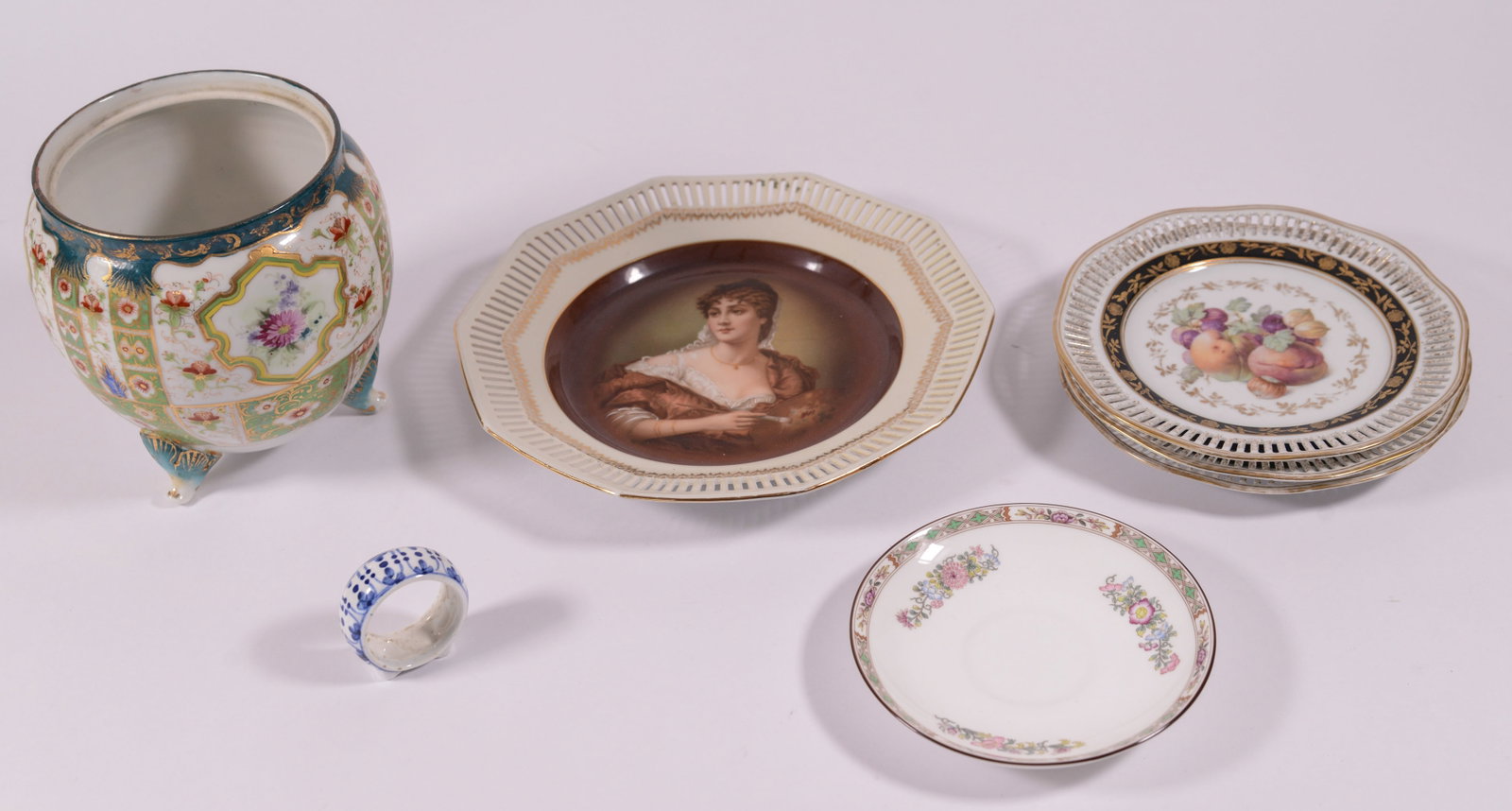 Group of Porcelain Items.: Four German plates with reticulated rims, largest 10 inches, a Wedgwood saucer, and a tripod base jar (lacking lid)