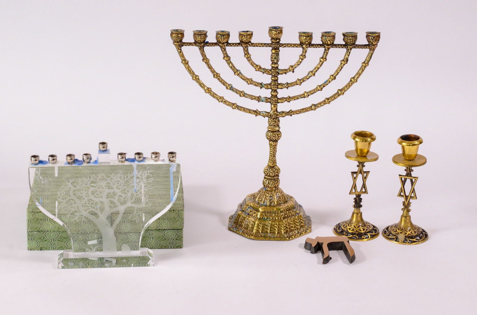 Two Menorahs and a Pair of Candlesticks.: One glass, in original box, height 7 inches, one brass, height 11 inches.