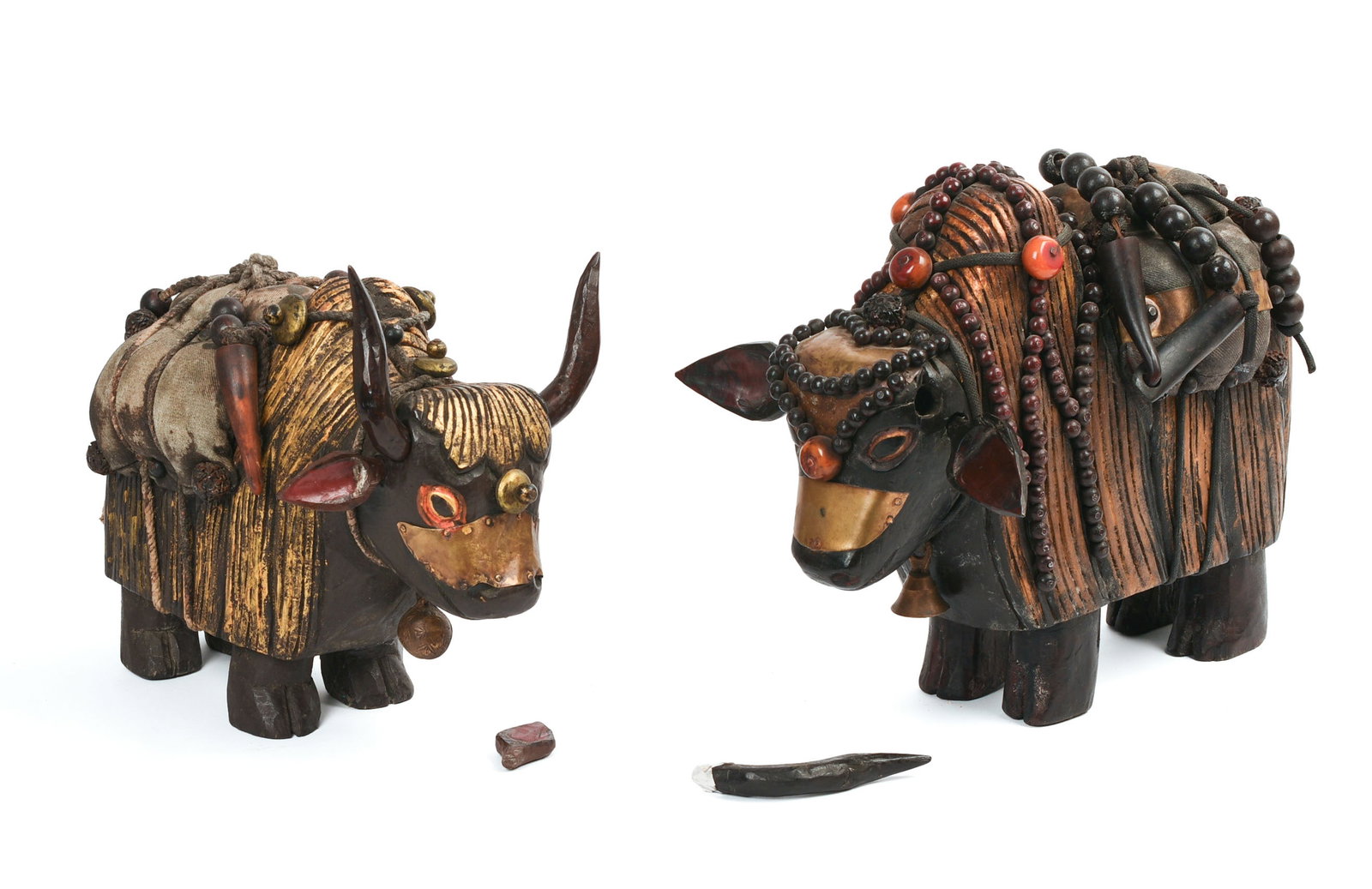 Pair of Tibetan Carved Wooden Yaks.: Length of larger 12 inches. Ears and horns are loose, one horn missing.