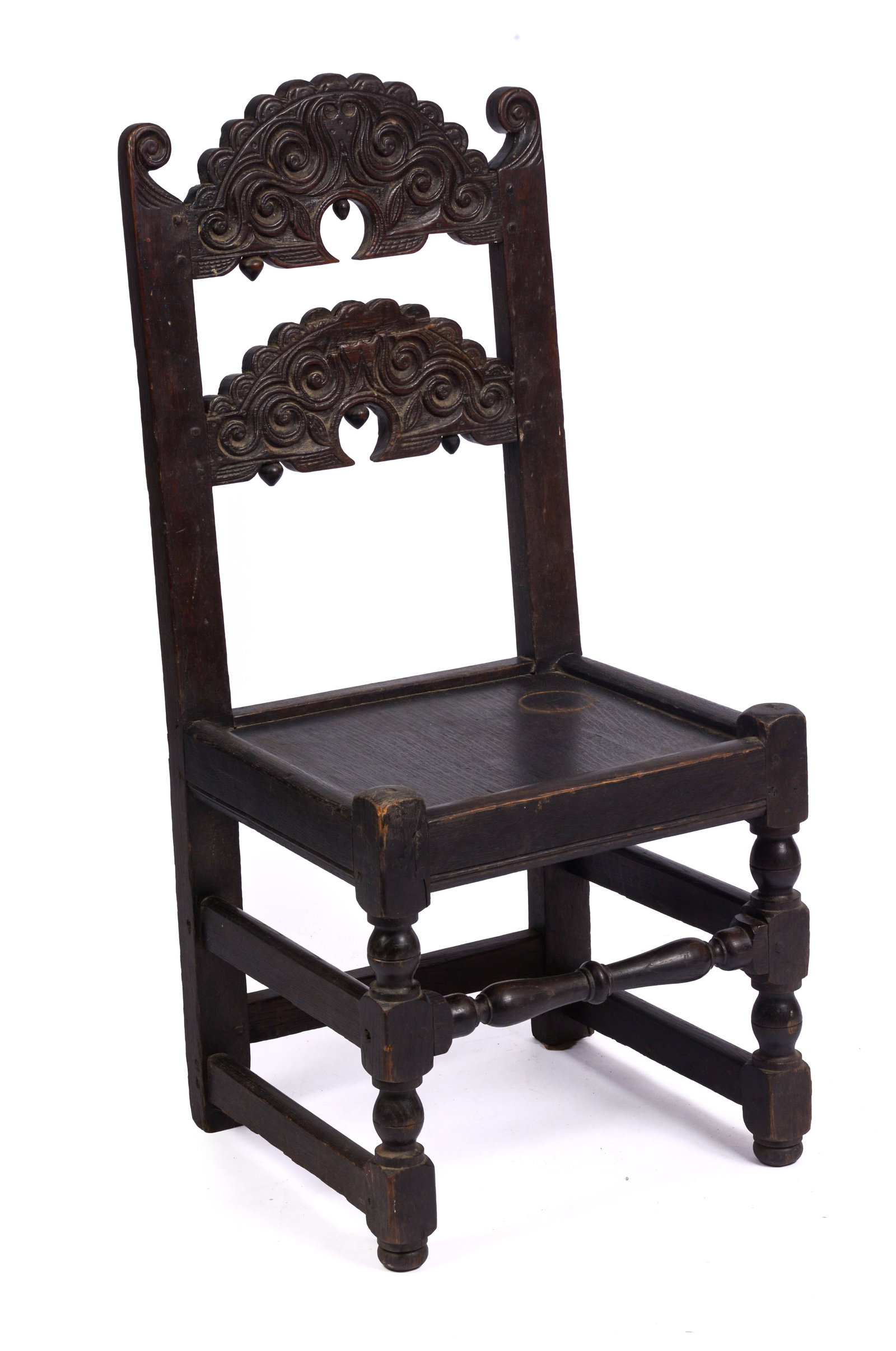 YORKSHIRE CARVED BACK STOOL. CIRCA 1670 - 1690.: Shaped back crest with carved scrolls and drop pendants. By repute, the carved center of the back rail covertly represents the head of Charles I, and the acorn from the oak tree in which he hid after
