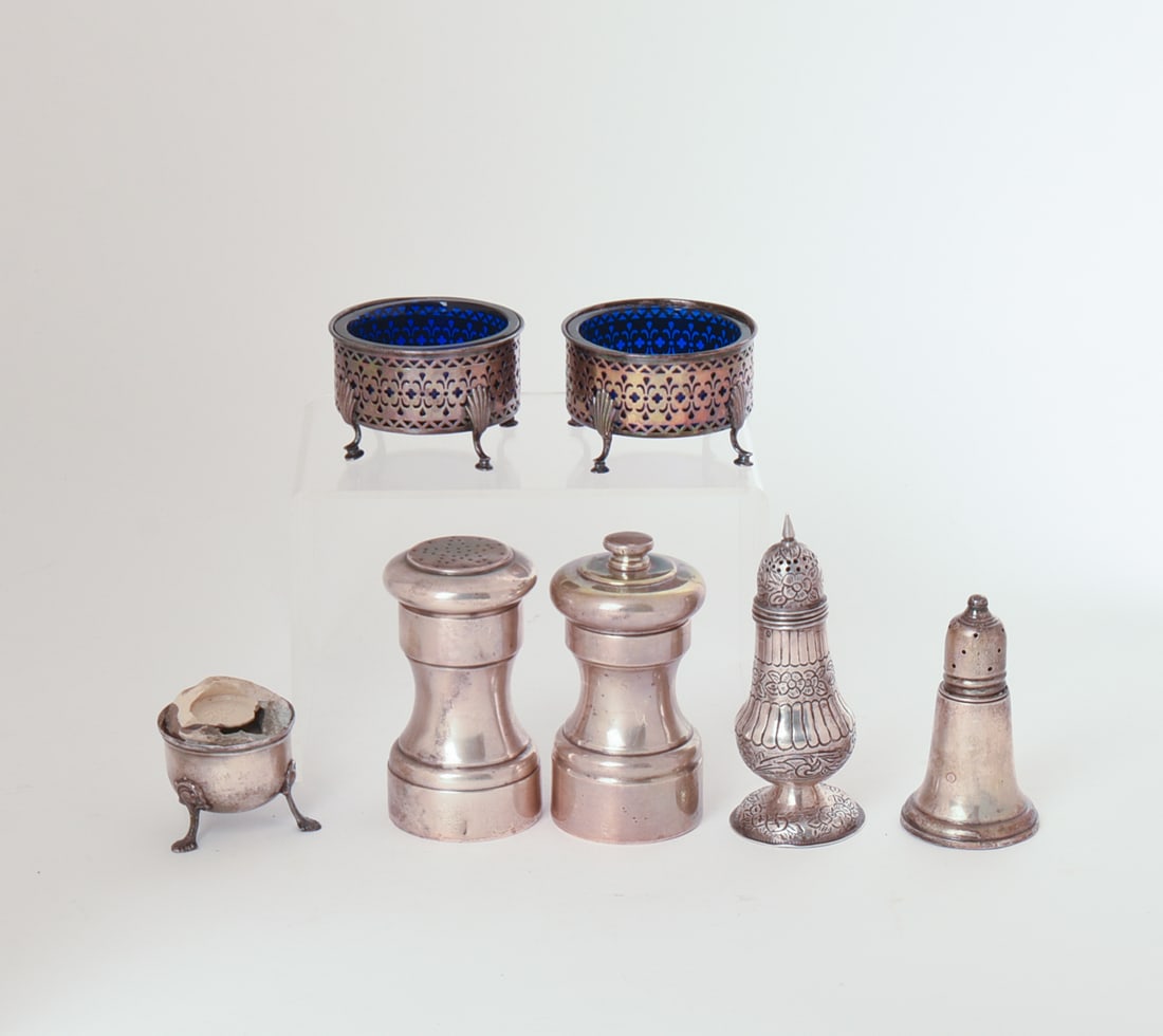 Five Silver Salts and a Pepper Grinder.: Includes Tiffany & Co, sterling, height 3.5 inches, two sterling with cobalt blue glass liners, one with English sterling hallmarks, one weighted sterling, and a sterling pepper grinder. Total