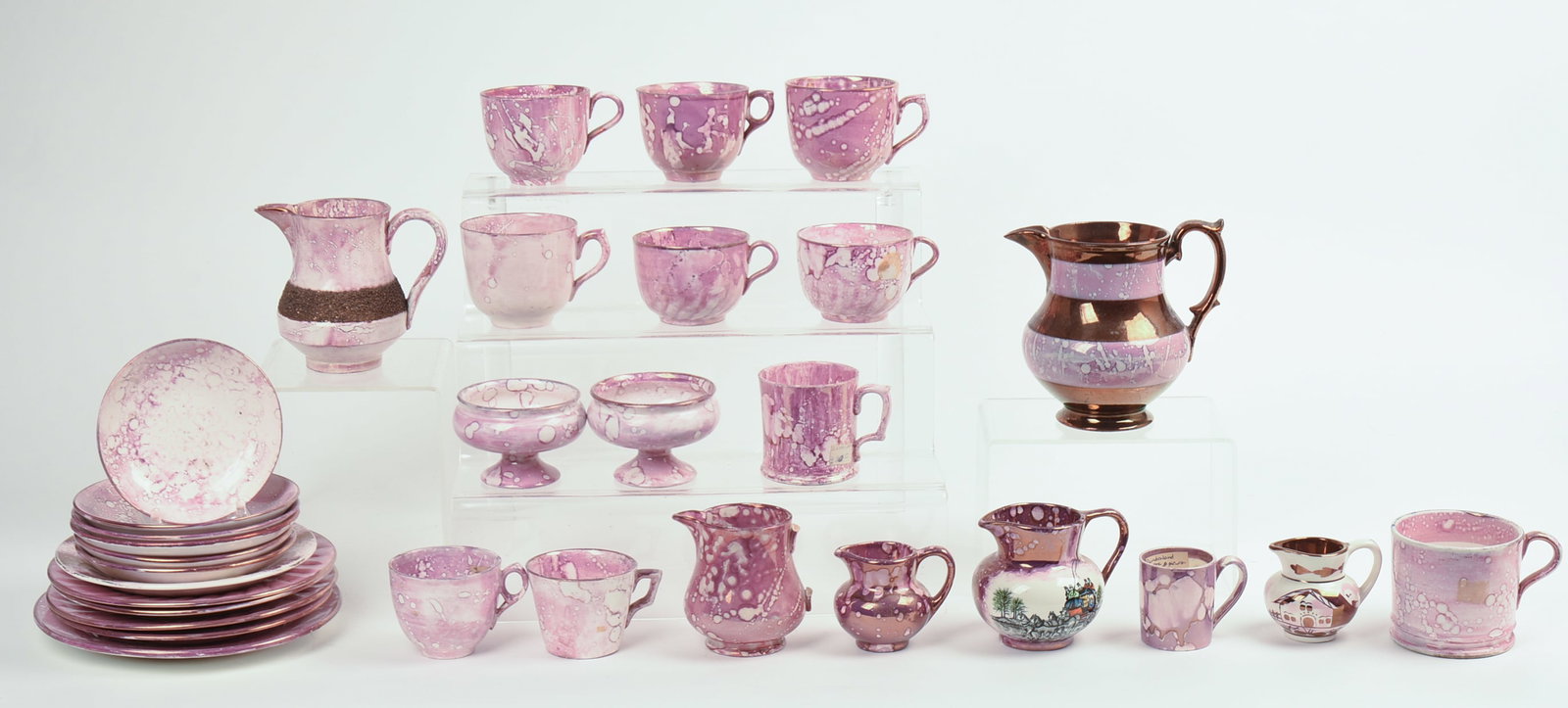 Collection of Pink Lustreware.: Includes six pitchers, tallest 5 inches, 11 teacups, pair of miniature compotes, and 12 small plates and saucers. 31 pieces total. A few small chips and hairlines, one pitcher with broken handle.
