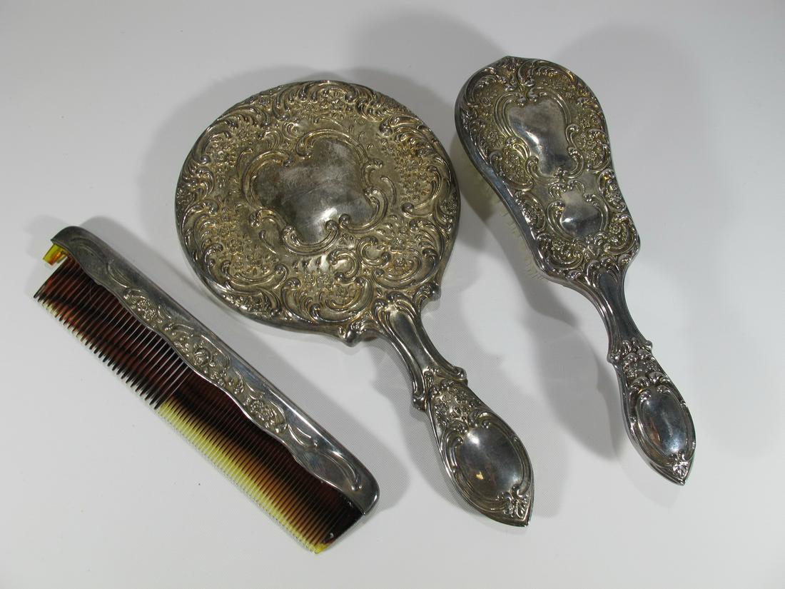 Antique silverplated vanity set.: Antique silverplated vanity set. Brush: 8 3/8 in H x 2 7/8 in W, Comb: 1 5/8 in H x 7 1/2 in W, Mirror: 9 1/2 in H x 5 1/4 in W.
