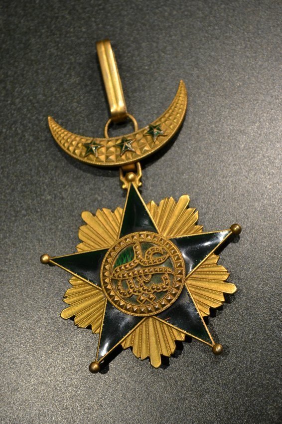 FRANCE COLONIAL ORDER OF STAR OF GRAND COMORO NECK TYPE: FRANCE COLONIAL ORDER OF STAR OF GRAND COMORO . HIGHEST DEGREE NECK ORDER . GILDED SILVER WITH BEAUTIFUL GREEN ENAMEL STAR WITH ISLAMIC INSCRIPTIONS. LATE 19TH CENTURY