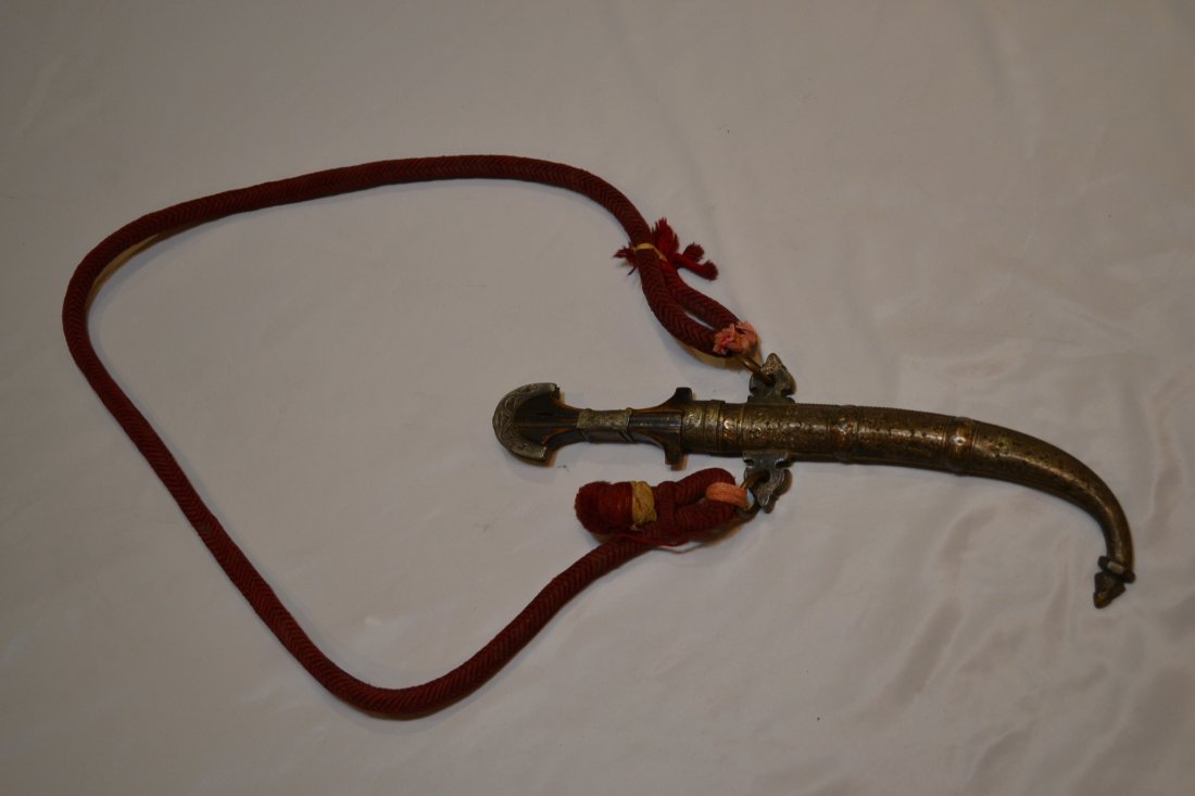 ANTIQUE ARABIAN MIDDLE EASTERN ISLAMIC JAMBIYA DAGGER: ANTIQUE ARABIAN MIDDLE EASTERN ISLAMIC JAMBIYA DAGGER. A REAL ANTIQUE WEAPON NOT A TOURIST DAGGER . SHARP CURVED BLADE WITH MAKER STAMP . HIGHLY DECORATED FITTING. CARRY ROPE . GREAT EXAMPLE. 16" LONG