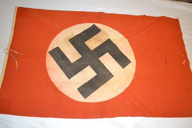 WWII NAZI GERMAN STATE FLAG FRENCH MADE: WWII NAZI GERMAN STATE FLAG. FRENCH MADE AND MAKER STAMPED. STAINS AND WEAR BUT STILL IN GOOD CONDITION. MULTI PIECE CONSTRUCTION. DOUBLE SIDED . 62" X 37"