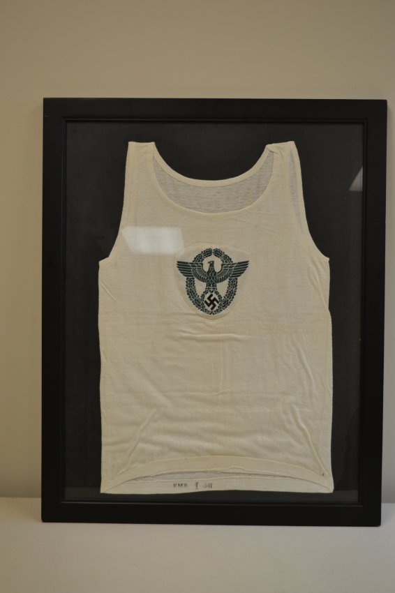 WWII NAZI POLICE SPORT SHIRT WITH INSIGNIA FRAMED: WWII NAZI POLICE SPORT SHIRT WITH INSIGNIA FRAMED . NICE MINTY CONDITION ORIGINAL WHITE POLICE SPORT SHIRT . INK STAMPED INSIDE . MOUNTED ON THE NICE DISPLAY FRAME WITH GLASS . READY TO DISPLAY ON THE