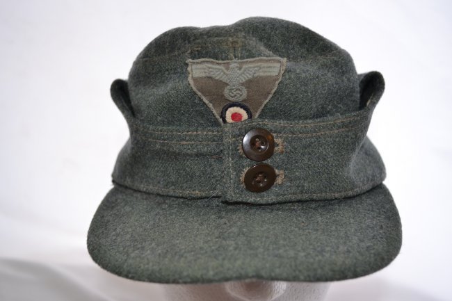 WWII GERMAN ARMY M43 LATE WAR ENLISTED CAP HAT: WWII GERMAN ARMY M43 LATE WAR SOLDIER'S CAP HAT . LATE WAR EXAMPLE WITH INSIGNIA APPLIED TO THE FRONT AND BAKELITE BUTTONS. SIZE 58 . GOOD CONDITION WITH NORMAL WEAR
