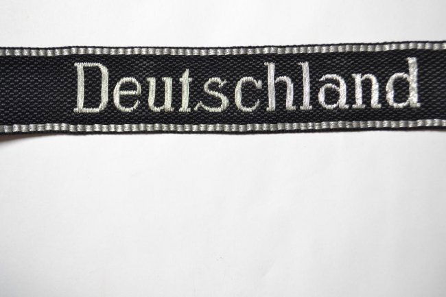 WWII GERMAN WAFFEN SS "DEUTSCHLAND" OFFICER CUFFTITLE: WWII German Waffen SS "DEUTSCHLAND" Officer's Flatwire Woven Cuff Title . Silver -aluminum wire woven name on black with silver - aluminum upper and lower edge borders. Full length with folded over, m