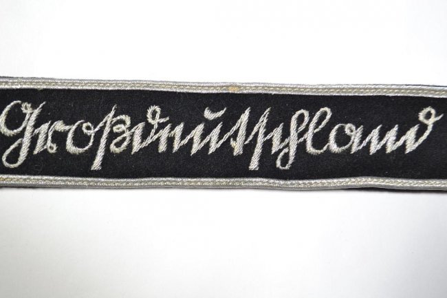 WWII GERMAN ARMY "Grossdeutschland" PZ. GR. CUFFTITLE: WWII GERMAN ARMY Panzer Grenadier Divison "Grossdeutschland"cufftitle . 3rd pattern . Black wool. The exterior trimmed along both edges with dual bands of silver aluminum wire piping, bearing a machin