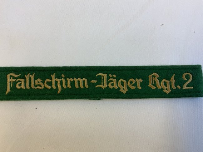 WWII GERMAN LUFTWAFFE "FALLSCHIRM-JÄGER RGT.2 CUFFTITLE: WWII GERMAN LUFTWAFFE PARATROOPER "FALLSCHIRM-JÄGER RGT.2" CUFFTITLE. EM/ NCO Style.Green wool cufftitle with machine embroidered Gothic script, "Fallschirm-Jäger Rgt. 2", in silver - grey cotton th