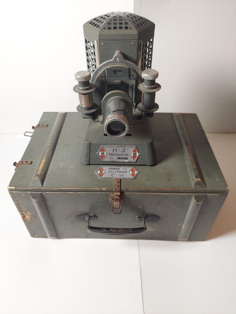 NAZI GERMAN HITLER YOUTH CASED PROJECTOR COMPLETE HJ: NAZI GERMAN HITLER YOUTH CASED SLIDE FILM PROJECTOR COMPLETE WITH ALL ACCESSORIES. ALL ORIGINAL WITH ORIGINAL LAMP STILL IN PLACE. MATCHING NUMBERS ON THE BOX AND PROJECTOR. ALL APPEARS TO BE IN GREAT